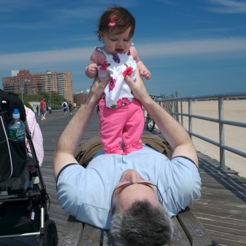 Sara and Daddy playing on the boardwalk in Coney Island