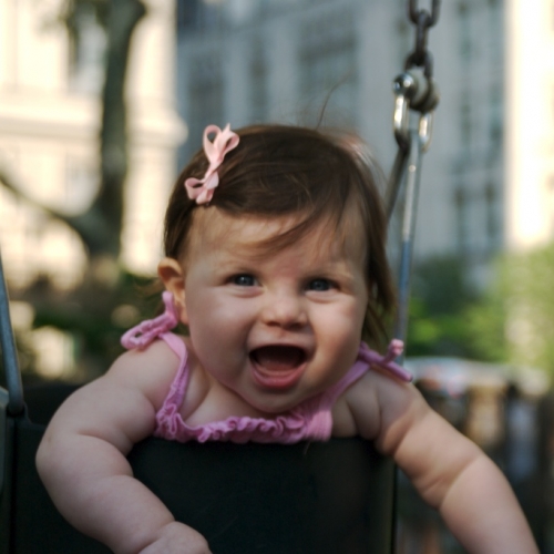 Sara giggles as she swings